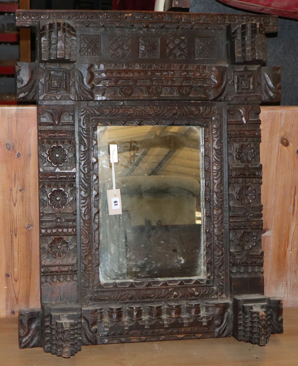 A carved oak wall mirror, W74cm, H.90cm